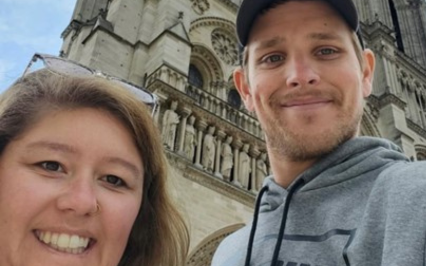 Close up photo of a woman and man in front of a gothic building